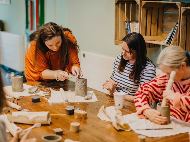 Women making ceramics by hand together